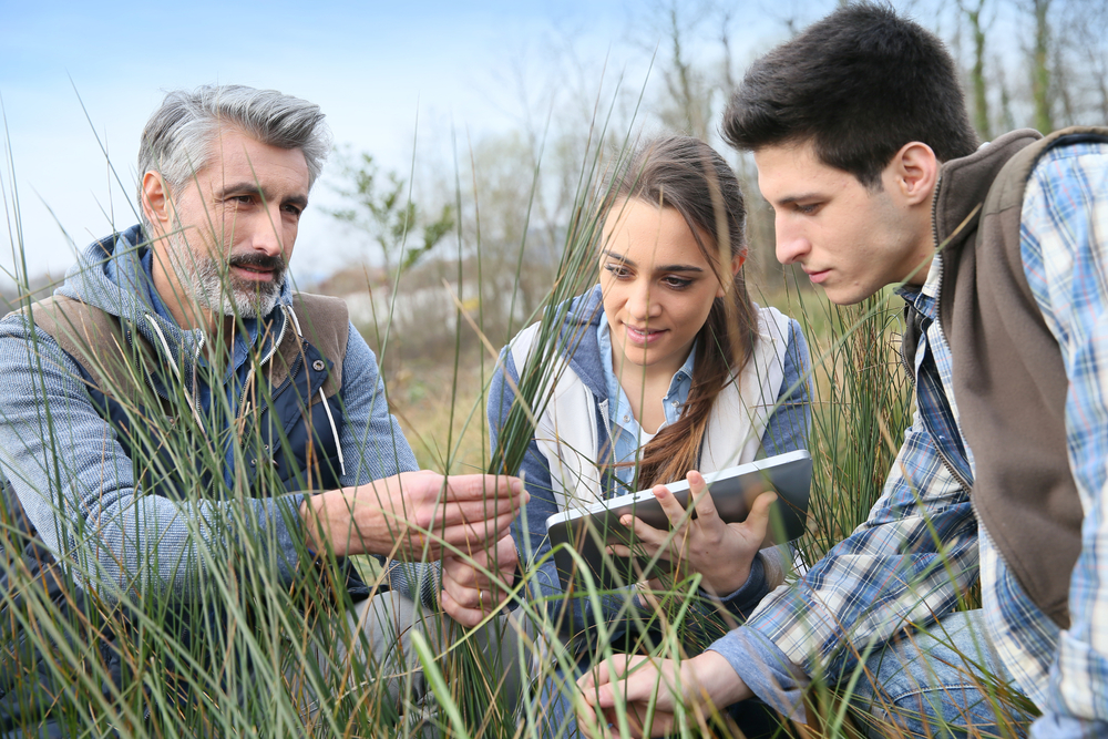 Teacher with students in agronomy looking at vegetation